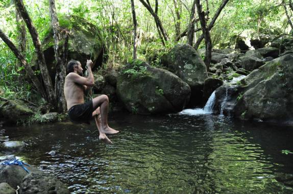 Diversão com um cipó em piscina natural na metade do caminho da trilha do Kalalau, na Na'Pali Coast, costa norte do Kauai, no Havaí